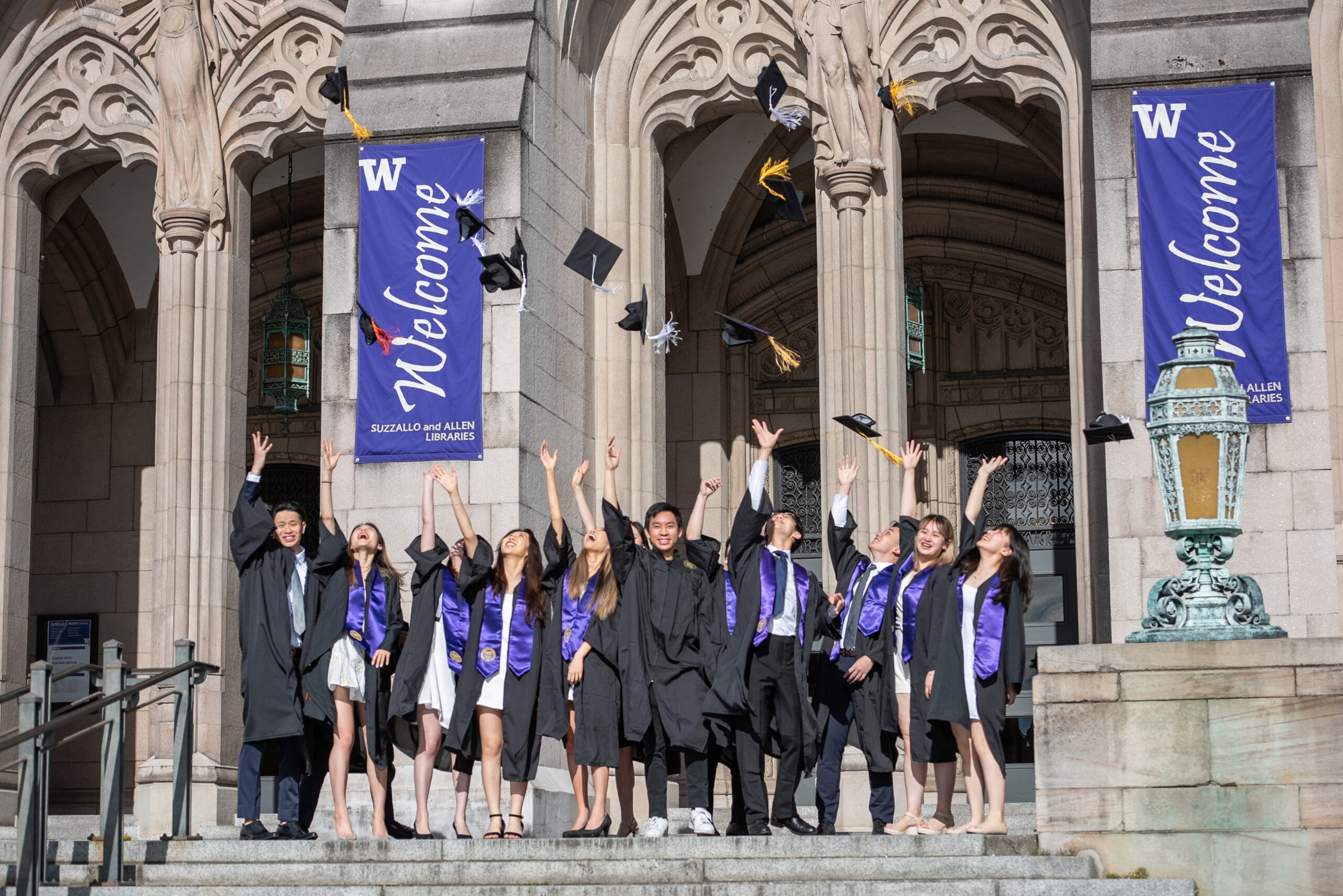 UW graduates tossing caps in front of Suzzallo Library